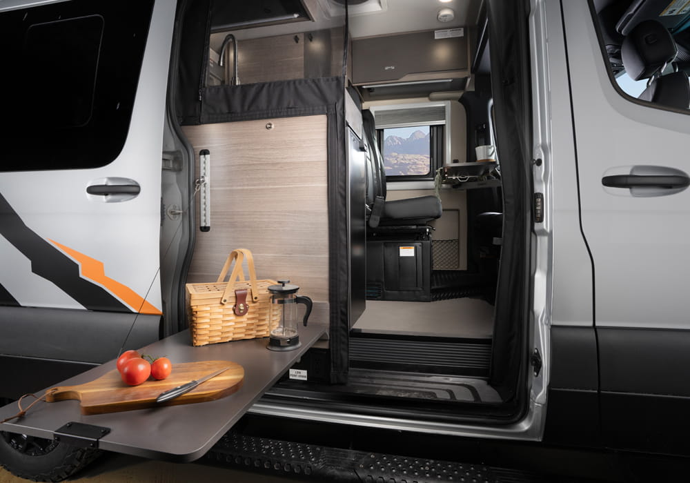 Entegra Coach Launch exterior galley with side door open at campsite