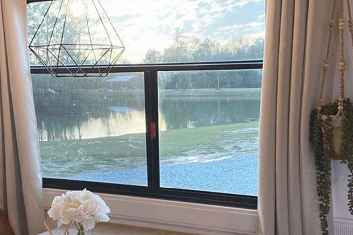 Window to the World: A view from inside an RV, looking out onto still waters and a green landscape.