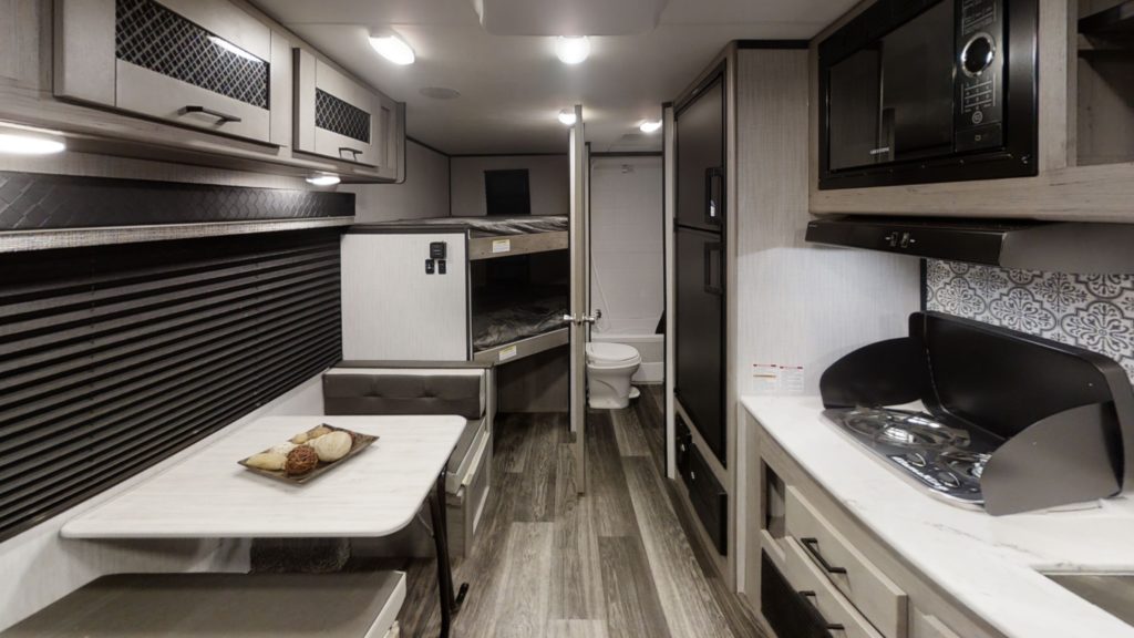 Interior of a Heartland Mallard small RV, showing a small dinette and kitchen.