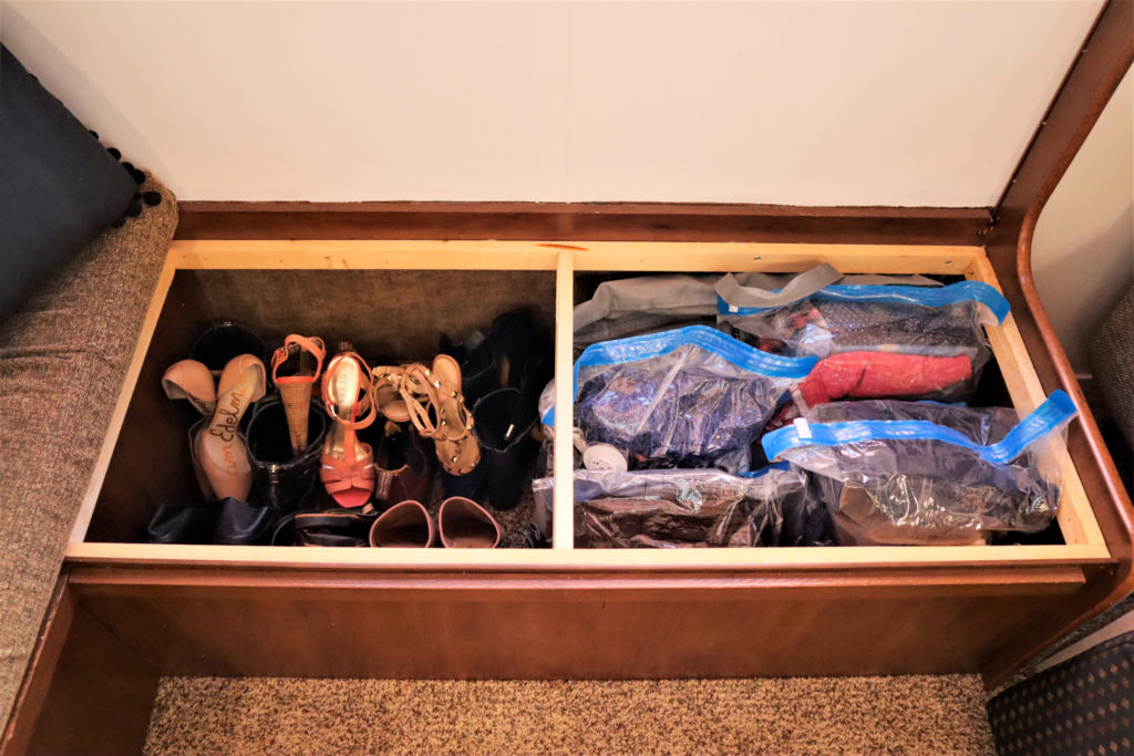Storing off-season shoes and vacuum-sealed clothes under the dinette bench.